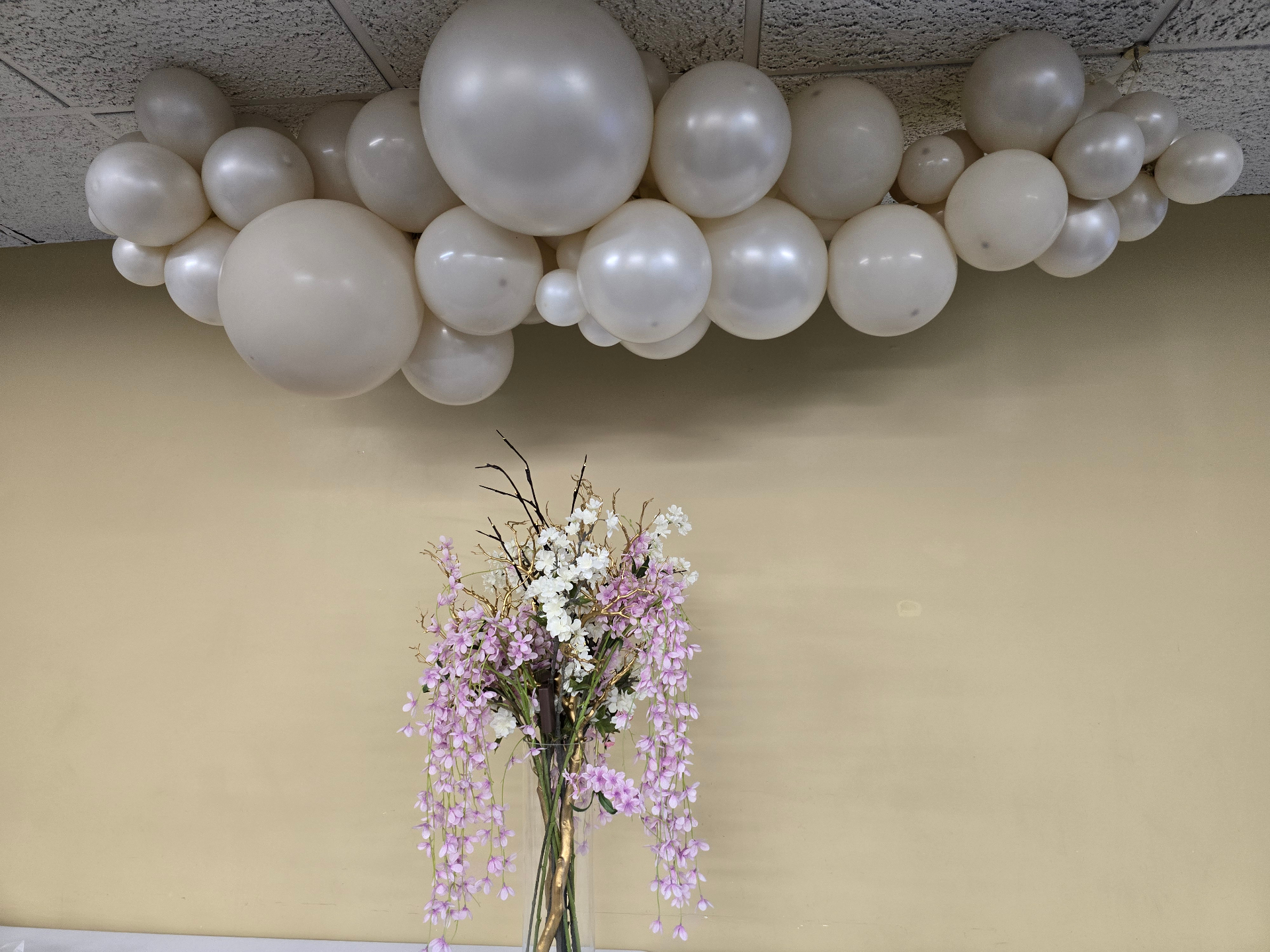 Cream and white balloon cloud installation with cascading pink floral centerpiece by Simone's Creations DMV