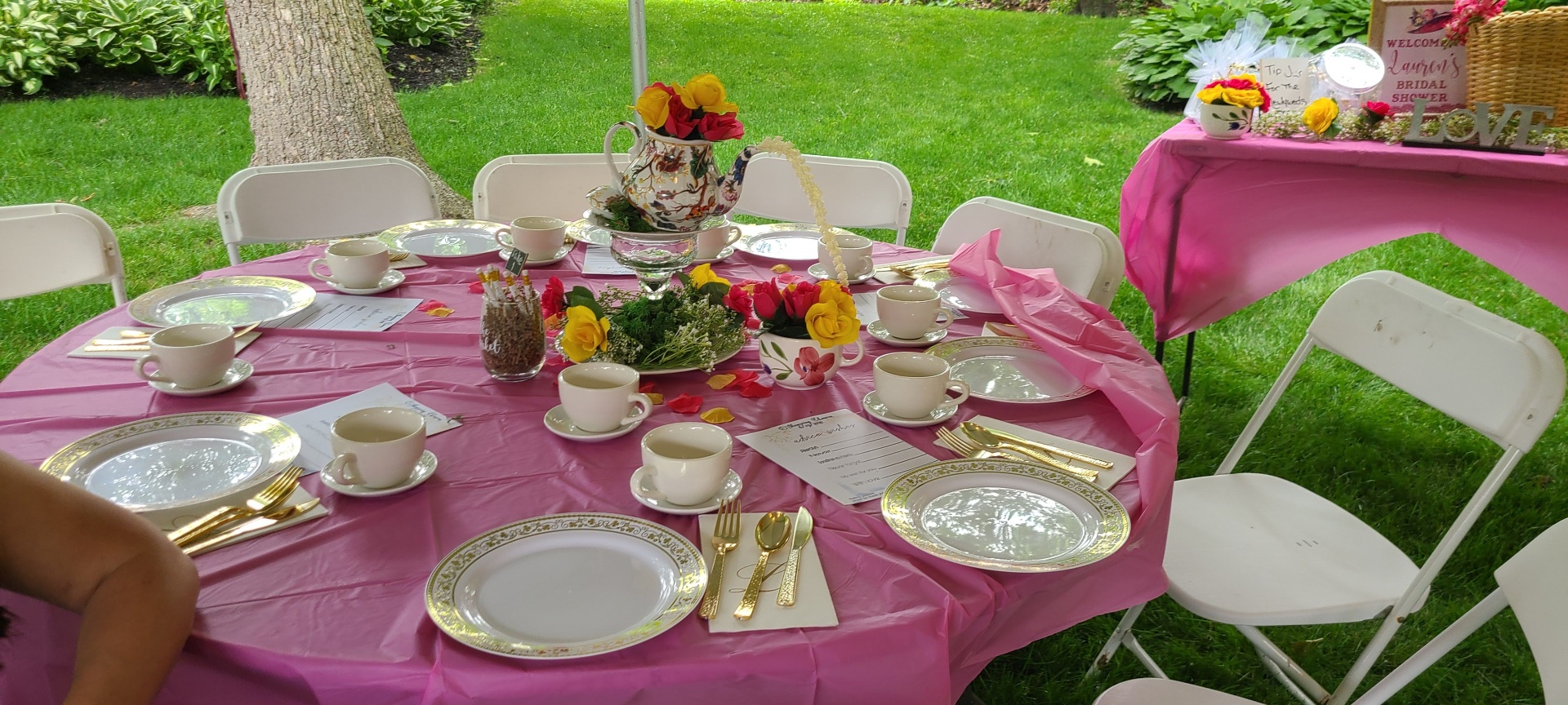Pink outdoor bridal shower tea party table setting with floral teapot centerpiece by Simone's Creations DMV
