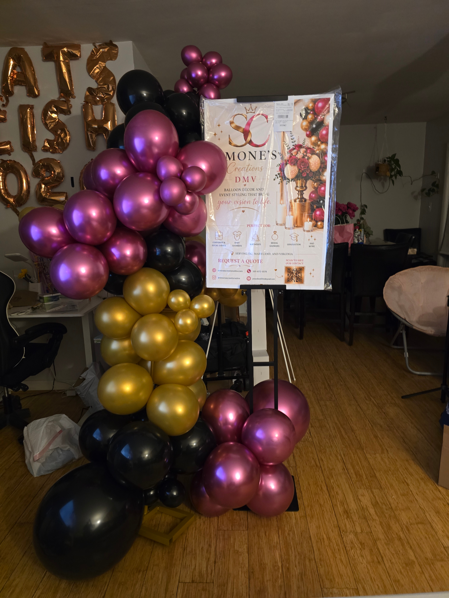 Magenta, gold, and black balloon cluster styled around Simone's Creations DMV sign